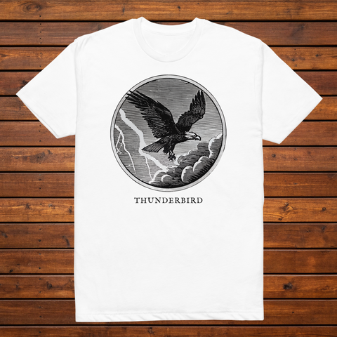 Thunderbird engraved cryptid t-shirt — black and white crosshatch medallion design on white tee, flat lay