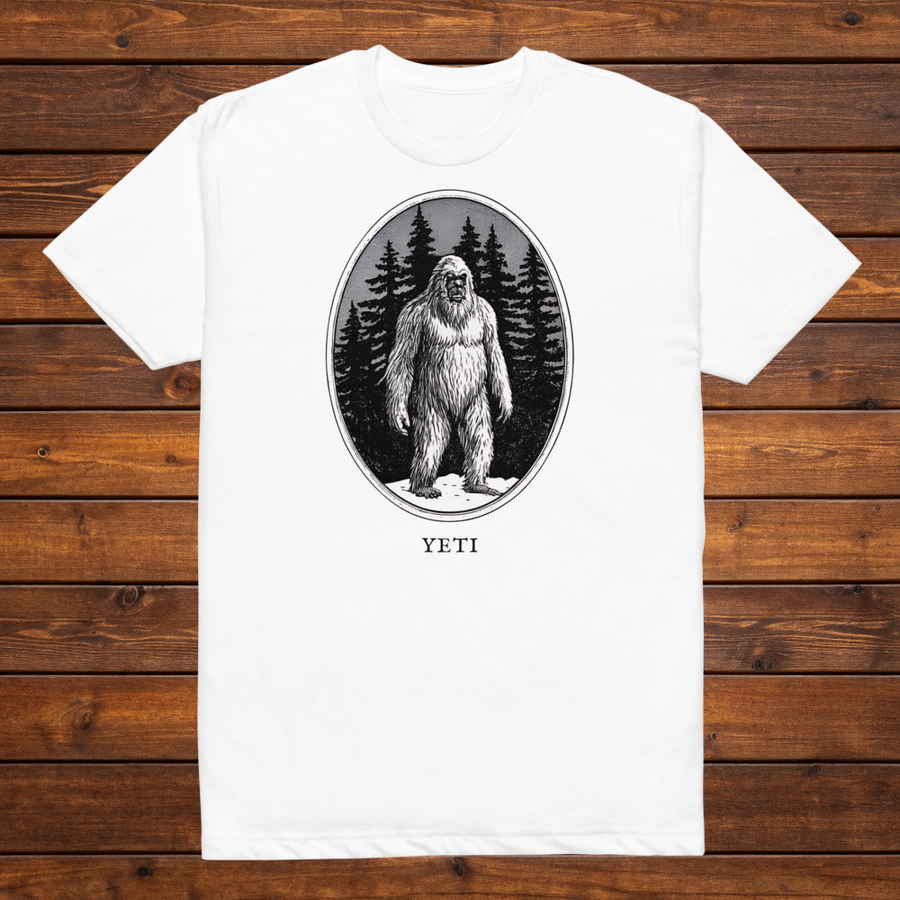 Yeti engraved cryptid t-shirt — black and white crosshatch medallion design on white tee, flat lay