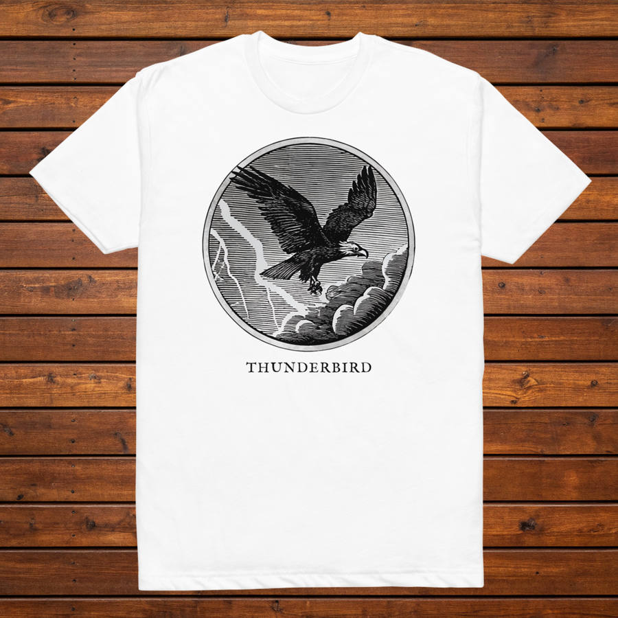 Thunderbird engraved cryptid t-shirt — black and white crosshatch medallion design on white tee, flat lay