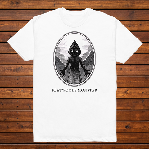 Flatwoods Monster engraved cryptid t-shirt — black and white crosshatch medallion design on white tee, flat lay