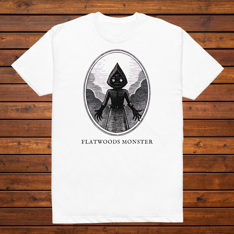 Flatwoods Monster engraved cryptid t-shirt — black and white crosshatch medallion design on white tee, flat lay